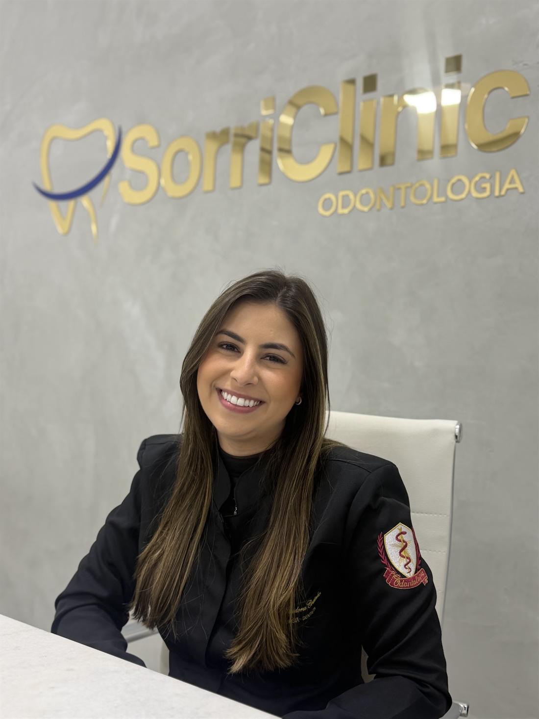 Cirurgiã-dentista da equipe SorriClinic sorrindo na recepção